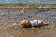 Old Doll Washing Ashore On A Mediterranean Beach