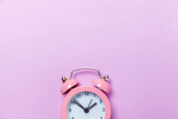 Ringing twin bell vintage classic alarm clock Isolated on purple violet pastel colourful background. Rest hours time of life good morning night wake up awake concept. Flat lay top view copy space