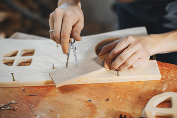 Wall Mural - A man carves a tree. The carpenter works in a studio. An engineer provides a tree shape