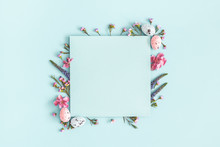 Easter Composition. Easter Eggs, Flowers, Paper Blank On Pastel Blue Background. Flat Lay, Top View, Copy Space