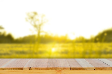 Wall Mural - Wood table top on blur grass background   background .summer,nature concepts.field of grass and sun in morning