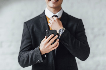 Wall Mural - Positive office worker advertising mobile app. Young caucasian man showing smartphone with copy space. Lifestyle!