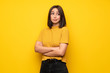 © luismolinero - Young woman over yellow wall making doubts gesture while lifting the shoulders