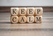 Cubes dice with keep calm on wooden background