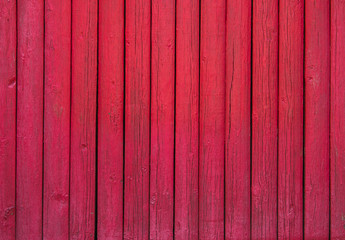 Close up of red painted wooden fence panels.