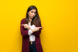 © luismolinero - Young woman over yellow wall pointing to the laterals having doubts