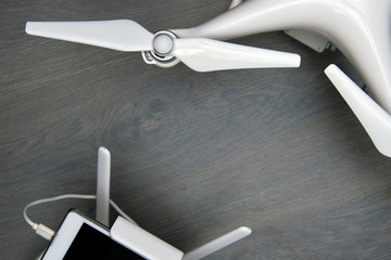 control panel with a fixed smartphone and a flying drone with a high-resolution camera on a wooden table with space for text