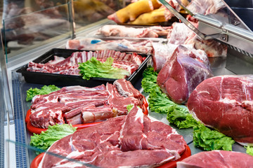 Pieces of lamb meat are on the counter in the market.