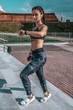 © byswat - Young athletic girl looks clock, measures pulse time, fitness workout, sportswear, leggings and top. In hand, phone listens music headphones. In summer city rest, online application social Internet.