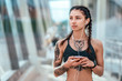 © byswat - Young athletic beautiful girl cat tattoos, morning before fitness, headphones listens music phone, online playlist application to Internet. sportswear top. Summer city workout. Free space for text.