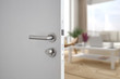 Door handle , door open in front of blur interior room background, selective focus