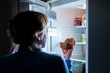 woman eating cake in the night from the fridge