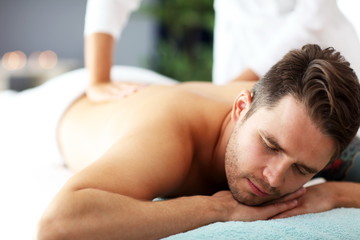 Handsome man having massage in spa salon