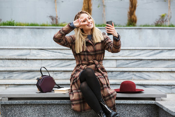 Sticker - Attractive young woman wearing coat sitting