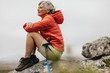 © Jacob Lund - Female trekker sitting on a rock relaxing