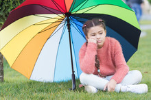 Autumn Depression. Spring Style. Depressive Mood In Autumn Rainy Weather. Little Girl Tired Under Colorful Umbrella. Multicolored Umbrella For Little Happy Girl. Rainbow After Rain. Feeling Depressed