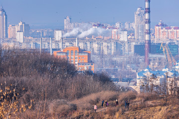 Early spring at sunny evening in warm weather. Industrial zone and residential areas Podin and northern suburbs Obolon in Kyiv on the right bank of the Dnipro River. Ukraine Mar. 6, 2019