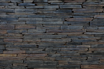 Wall Mural - Rustic dark stone wall background for texture and design backdrop purpose