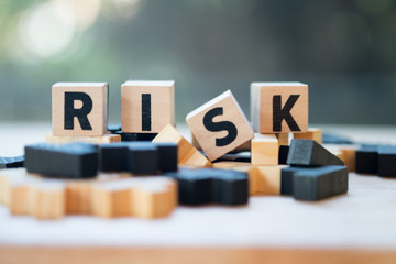 cube wooden block with alphabet building the word risk. risk assessment