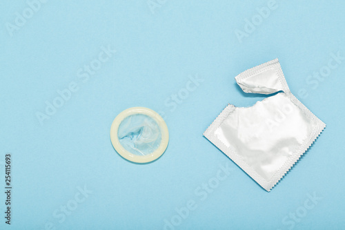 Fotomural Opened condom and condom in pack on a blue background