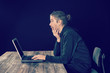 © Firma V - man in black hoody with laptop looking surprised