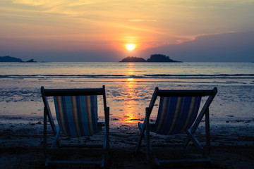 Sun loungers on the sea beach during twilight.