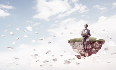 Young businessman or student studying the science and paper planes fly around