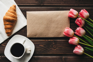 Wall Mural - Cup of coffee with a bouquet of pink Tulip flowers and a croissant for the morning Breakfast