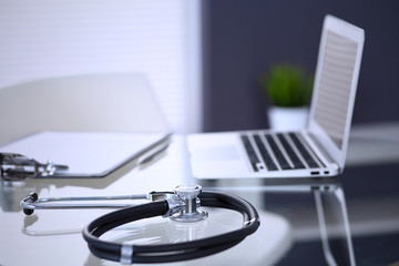 Stethoscope, prescription medical form lying on glass table with laptop computer. Medicine or pharmacy concept. Medical tools at doctor working table