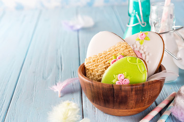 Sticker - Colorful easter bunny cookies in bamboo bowl on blue wooden background