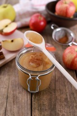 Wall Mural - homemade apple jam , apple puree, with cinnamon, fresh apples and a wooden spoon on wooden rustic table