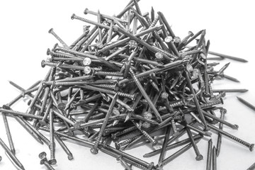 The pile of metal nails lies on the white background.