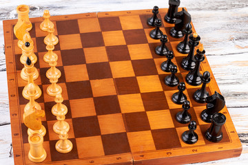 Wall Mural - Wooden chess pieces placed on chess board. Group of white and black chess figures. Life is a game.