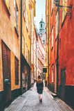 Fototapeta Uliczki - Woman tourist walking alone in Stockholm narrow street traveling lifestyle summer vacations in Sweden