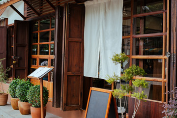 A front of restaurant or cafe Japan style, decorative with white fabric and menu tray.