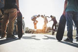 Skaters jumping with skateboard in city skate park - Main focus on center guys heads