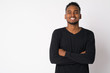 © Ranta Images - Portrait of happy young handsome African man smiling with arms crossed