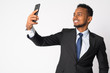 Happy young handsome African businessman taking selfie
