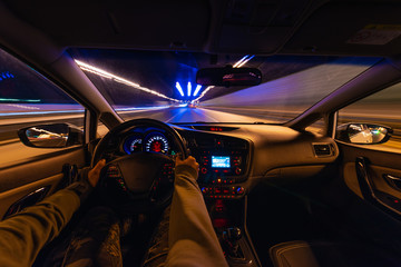 driving a car at night at high speed view from the car. blurry city lights.