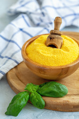 Wall Mural - Traditional uncooked Italian polenta in a wooden bowl.