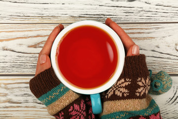 Wall Mural - Woman hands hold full cup of black tea