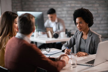 Wall Mural - Couple going through investment plans with African American bank manager.