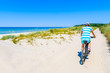 © pkazmierczak - Young woman riding bicycle along sandy beach on Hiddensee island, Germany, Baltic Sea