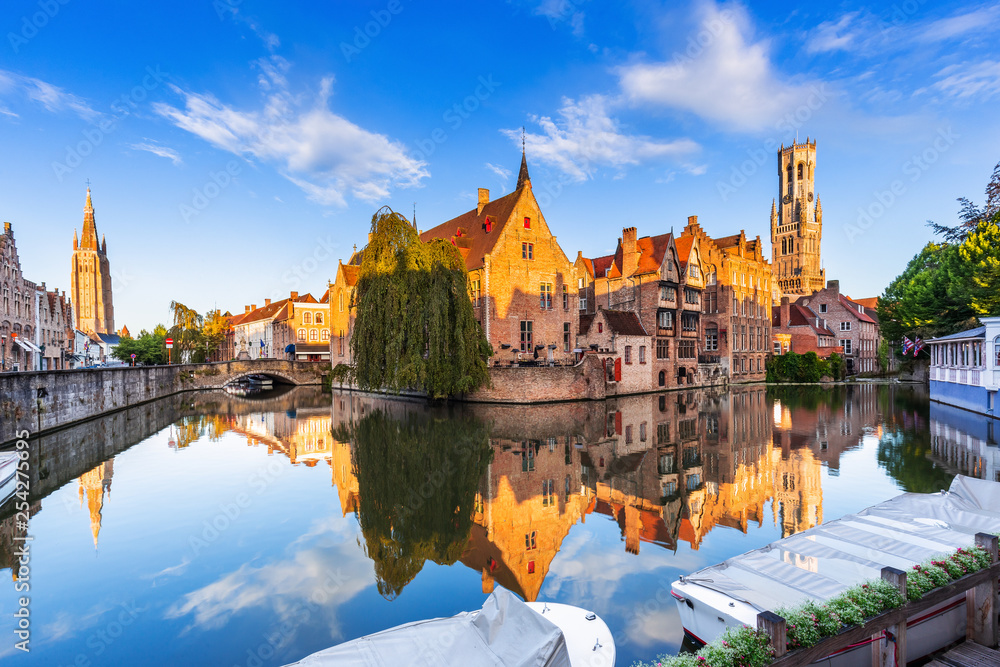 Bruges, Belgium. The Rozenhoedkaai canal in Bruges with the Belfry in the background. - obrazy, fototapety, plakaty 