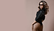 Young sensual beautiful sexy woman posing in fashion black leather jacket with nice ass buttocks and fashion sunglasses