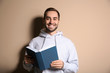 © New Africa - Young happy man with book on color background