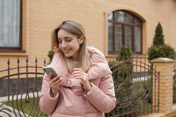 Sticker - Beautiful young woman using mobile phone outdoors