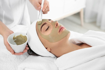 Poster - Cosmetologist applying mask on client's face in spa salon