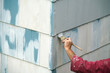 close up on handyman painting the exterior wall of the house
