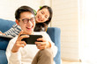 happiness asian sweet couple enjoy game on smartphone together living room home background